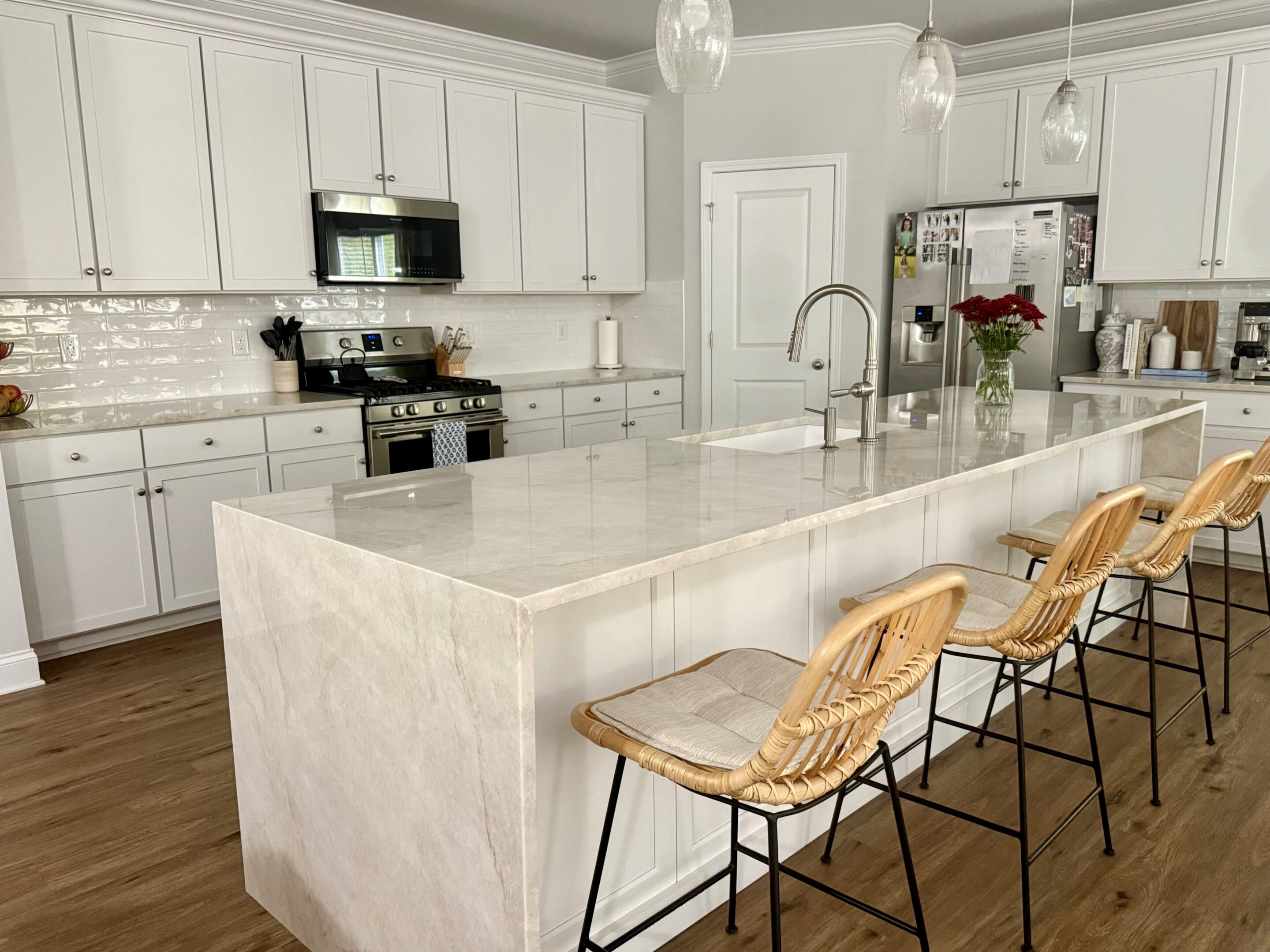 Modern white kitchen with marble island and stools
