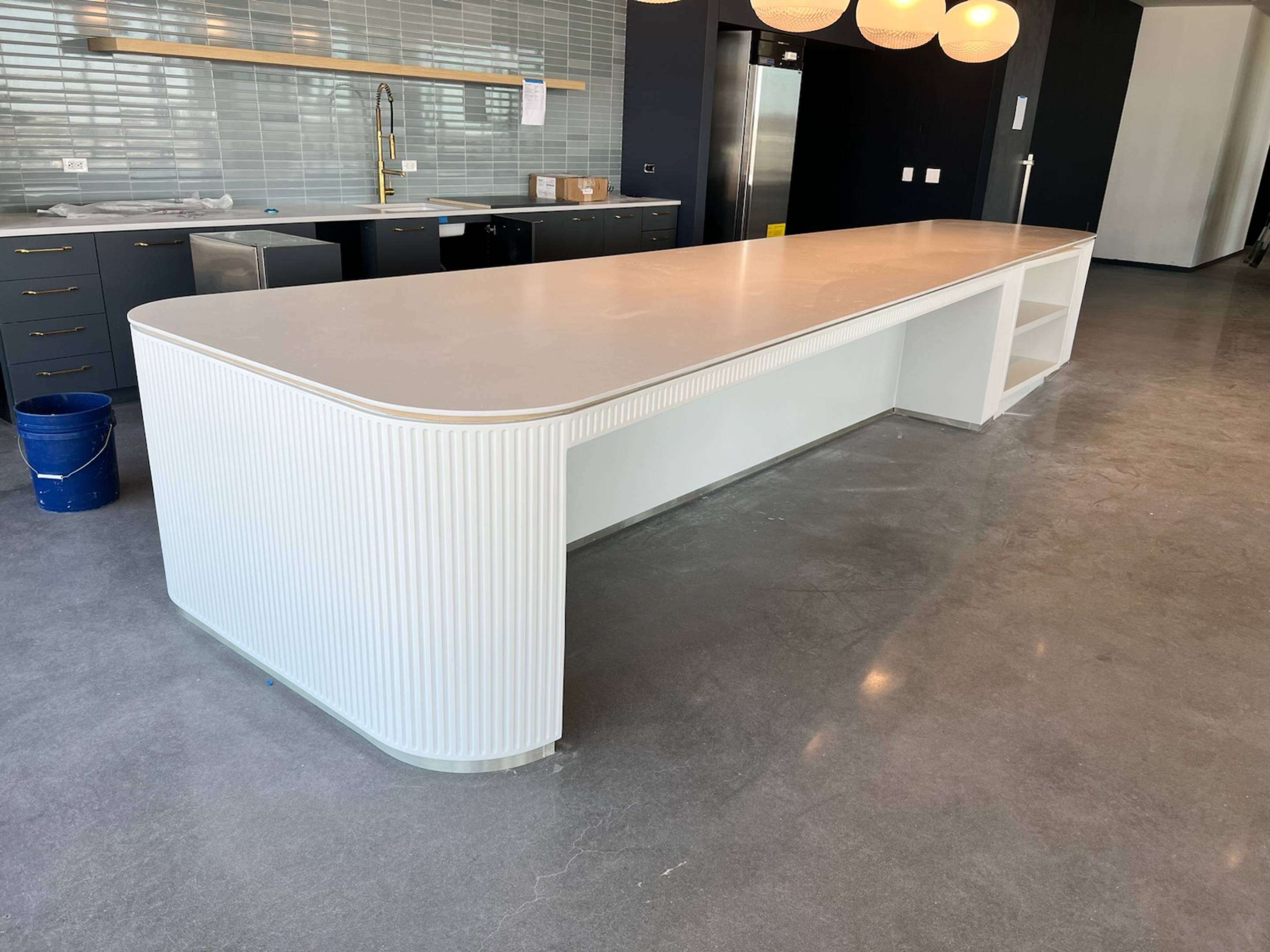 Long white kitchen island with pendant lights